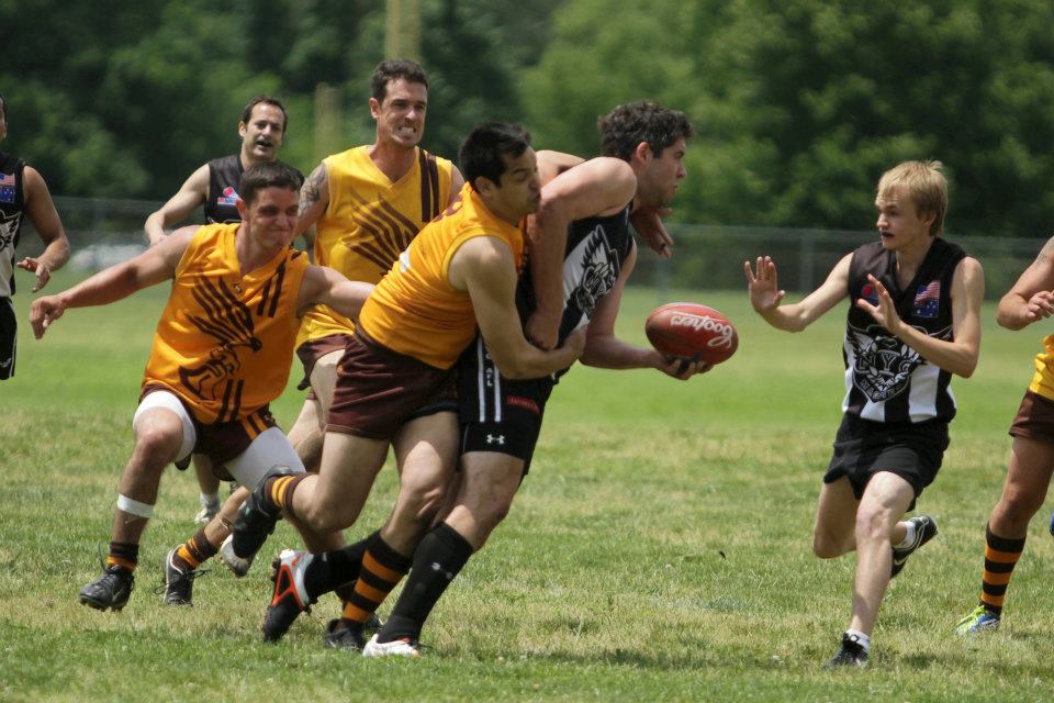 Fred Getz (Center, gold uniform) of the Philadelphia Hawks Australian Football Club tackles an opponent during a match against the New York Magpies in July, 2012.